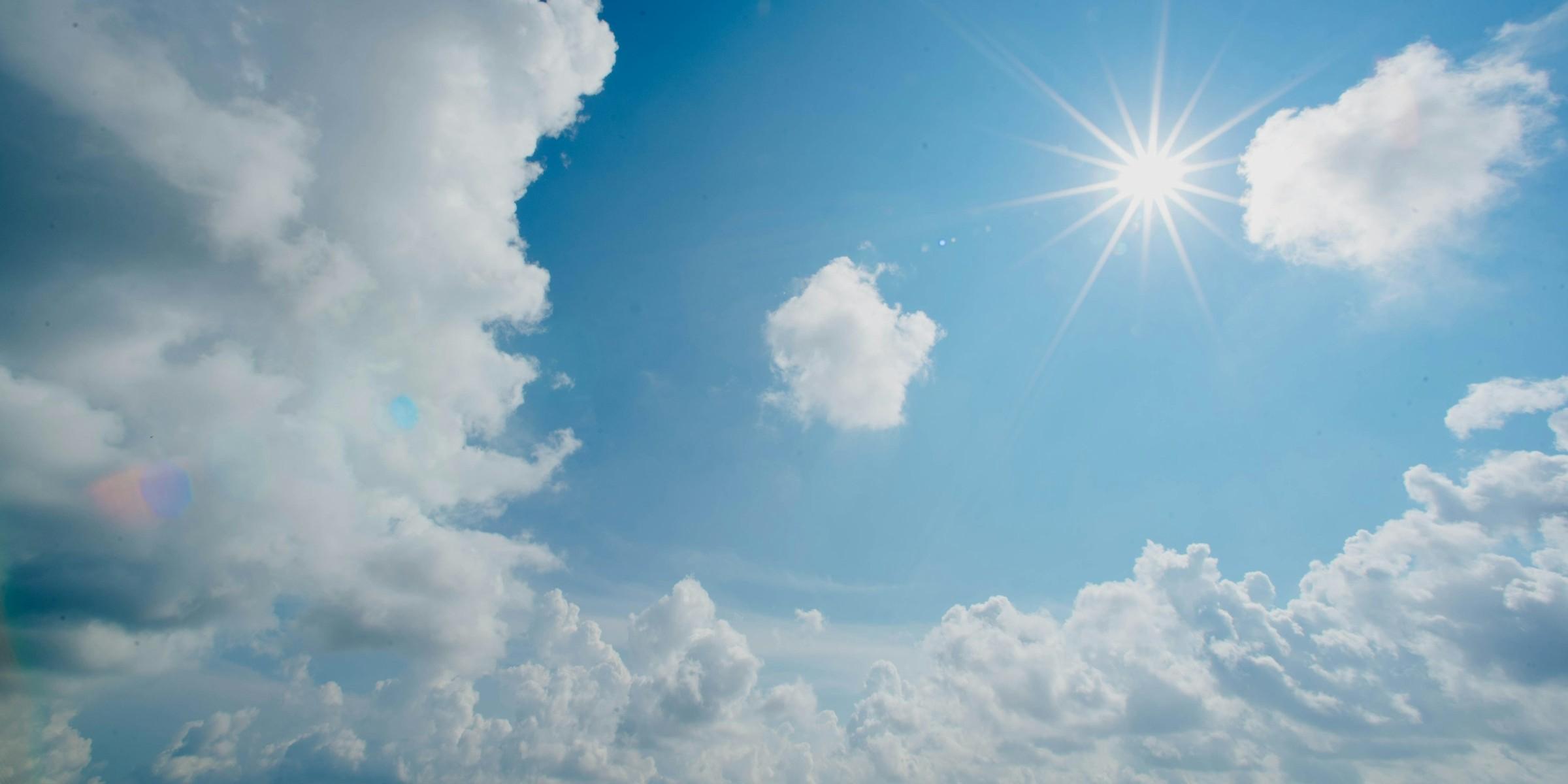 White and blue cloudy sky with sun